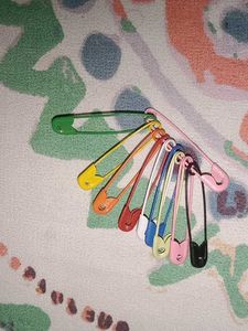 colorful safety pins and false nails