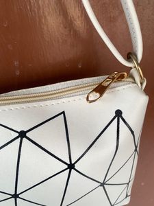 Brand new Ladies White sling bag in black design.