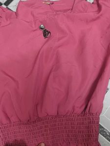 Chic Pink Smocked Top with Brooch Detail