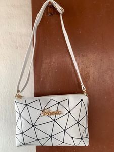Brand new Ladies White sling bag in black design.