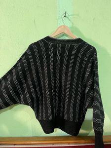 black V-neck sweater with wide, dolman-style sleev