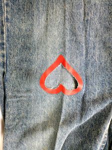blue washed jeans with heart shape cut out .