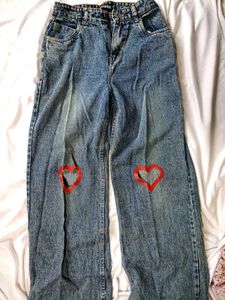blue washed jeans with heart shape cut out .