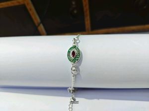 Elegant Pure Silver Rakhi with Red and Green Stone
