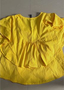 yellow styled top. flare on sleeves and neck