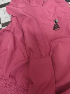 Chic Pink Smocked Top with Brooch Detail