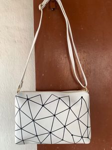 Brand new Ladies White sling bag in black design.