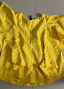 yellow styled top. flare on sleeves and neck