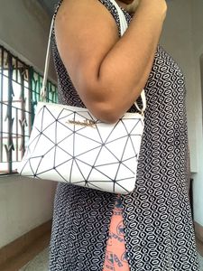 Brand new Ladies White sling bag in black design.