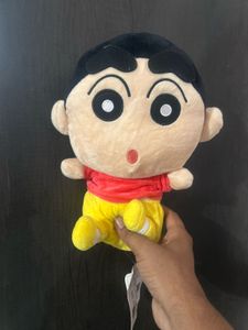 Shin-chan wearing a red shirt and yellow shorts