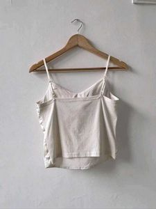 Off-white satin strappy top.