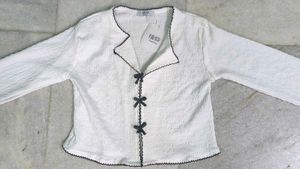 White textured top with black ribbon bows