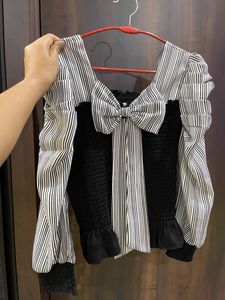 Black top with puffed sleeves and bow at the back