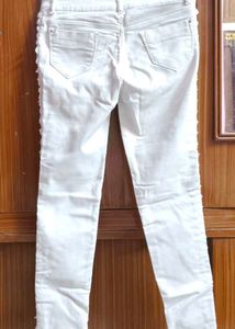 Pure white skinny-fit jeans featuring elegant pear