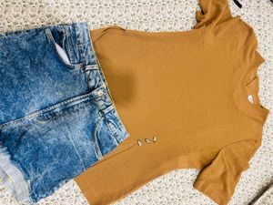 a short-sleeve top paired with blue denim short