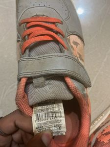 Gray sneakers with orange laces