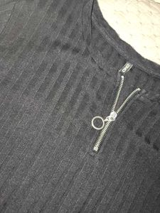 The image features a black ribbed top characterize