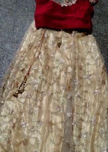 The maroon  lehenga   with golden colour net gown