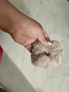 A pair of white and fur scrunchies