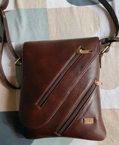 coffee brown coloured sling leather bag