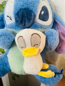Stitch holding a duck plushie!
