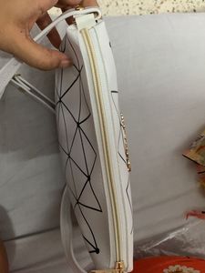 Brand new Ladies White sling bag in black design.