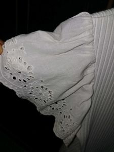 White ribbed crop top with flare sleeves.