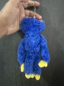 A blue Huggy Wuggy plush keychain from the horror