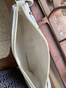 Brand new Ladies White sling bag in black design.