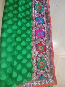 a printed saree with net in green color which look