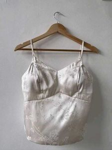 Off-white satin strappy top.