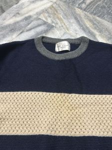 a knit sweater in shades of navy blue and beige