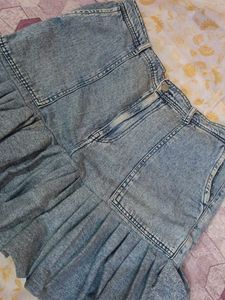It's a Y2K style denim skirt with funky ruffles.