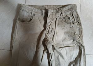 Mufti jeans in a light beige or khaki color featur