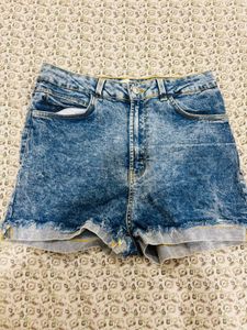 a short-sleeve top paired with blue denim short