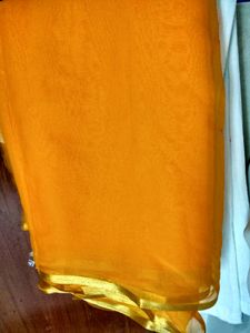 Simple Saffron colour chiffon saree with fine gold border