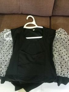 Chic Black Top with Polka Dot Sleeves
