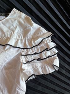 Chic White Ruffle Top with Black Trim