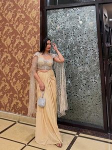 Golden sequined crop top with dhoti skirt and cape