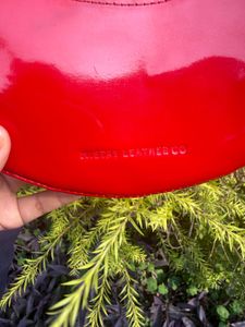 Shop Mistry Red Patent moon bag