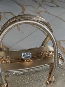 Elegant Gold Clutch with Gemstone Accent