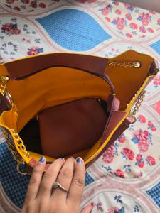 Chic Maroon Handbag with Gold Chain Accents