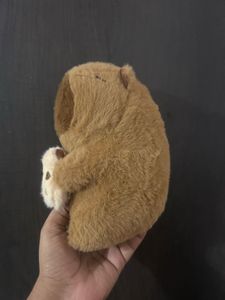 Capybara plush toy holding a small bread or toast