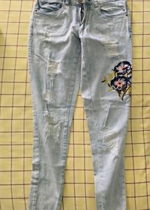 Denim jeans with flower pattern stitched on it
