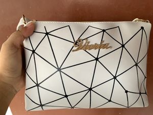 Brand new Ladies White sling bag in black design.
