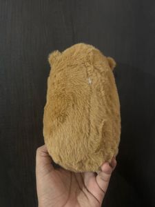 Capybara plush toy holding a small bread or toast