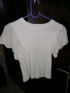 White ribbed crop top with flare sleeves.