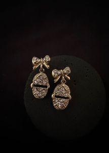 Gold Tone Bow Egg Dangle Earrings