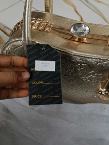 Elegant Gold Clutch with Gemstone Accent