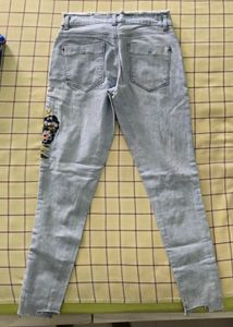 Denim jeans with flower pattern stitched on it